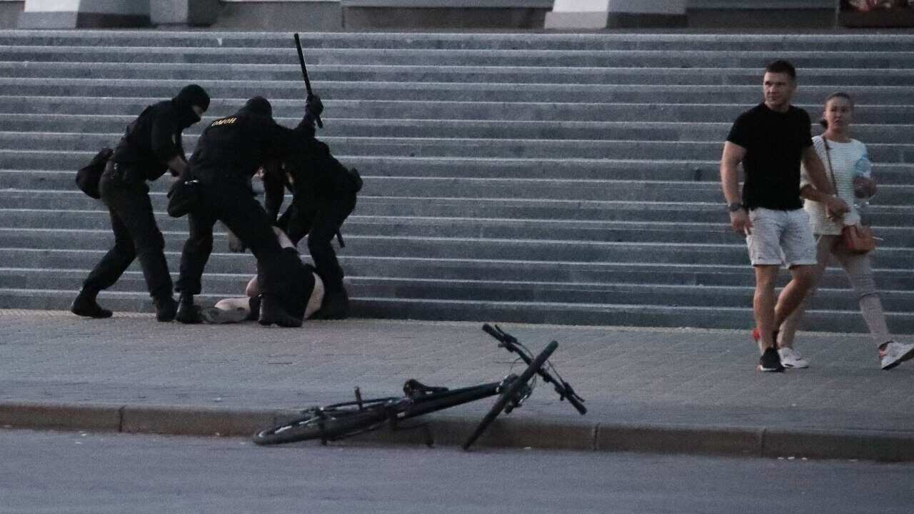 Belarusian riot policemen detain an unidentified person in Minsk