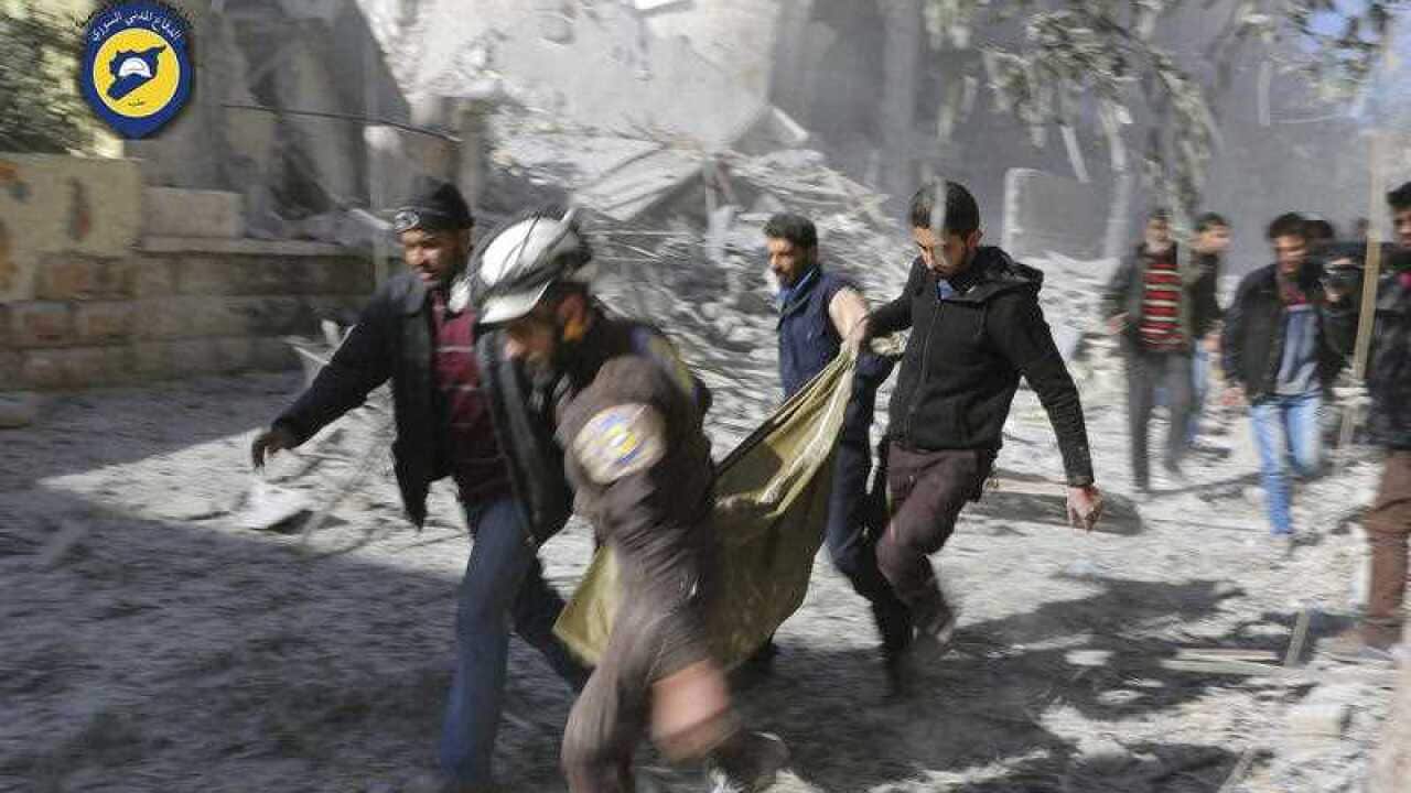 Civil Defense workers and Syrian citizens carry a dead body in the neighborhood of Seif al-Dawleh in Aleppo, Syria, Saturday, Nov. 19, 2016.