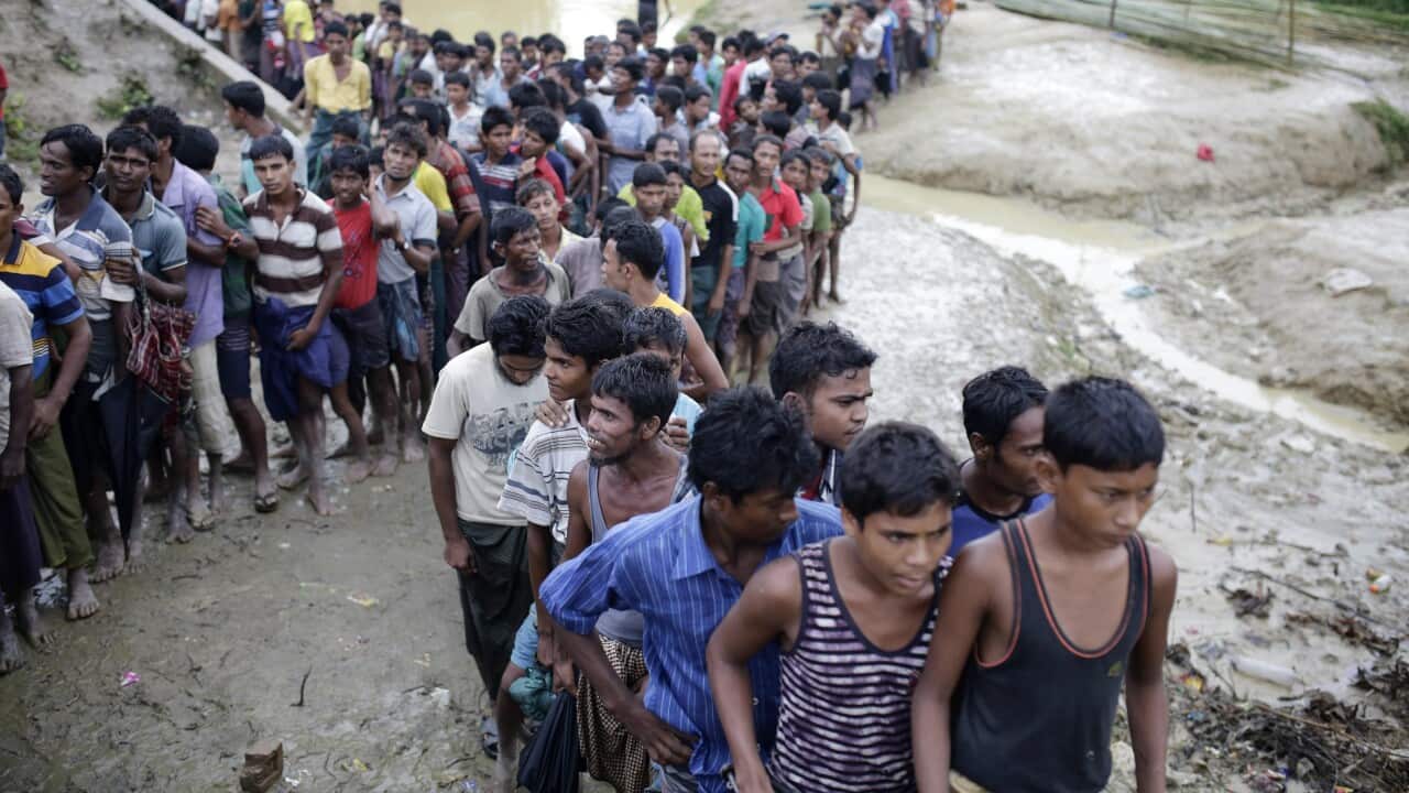 Rohingya refugees stand in a queue as they wait to collect relief goods in Ukhiya, Coxsbazar, Bangladesh.