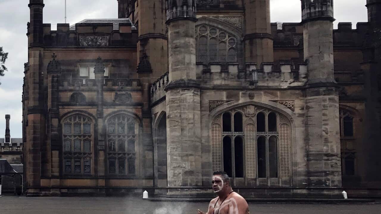 A dancer from Koomurri Aboriginal Dance Troupe performs the smoking ceremony in front of the Government House in Sydney.