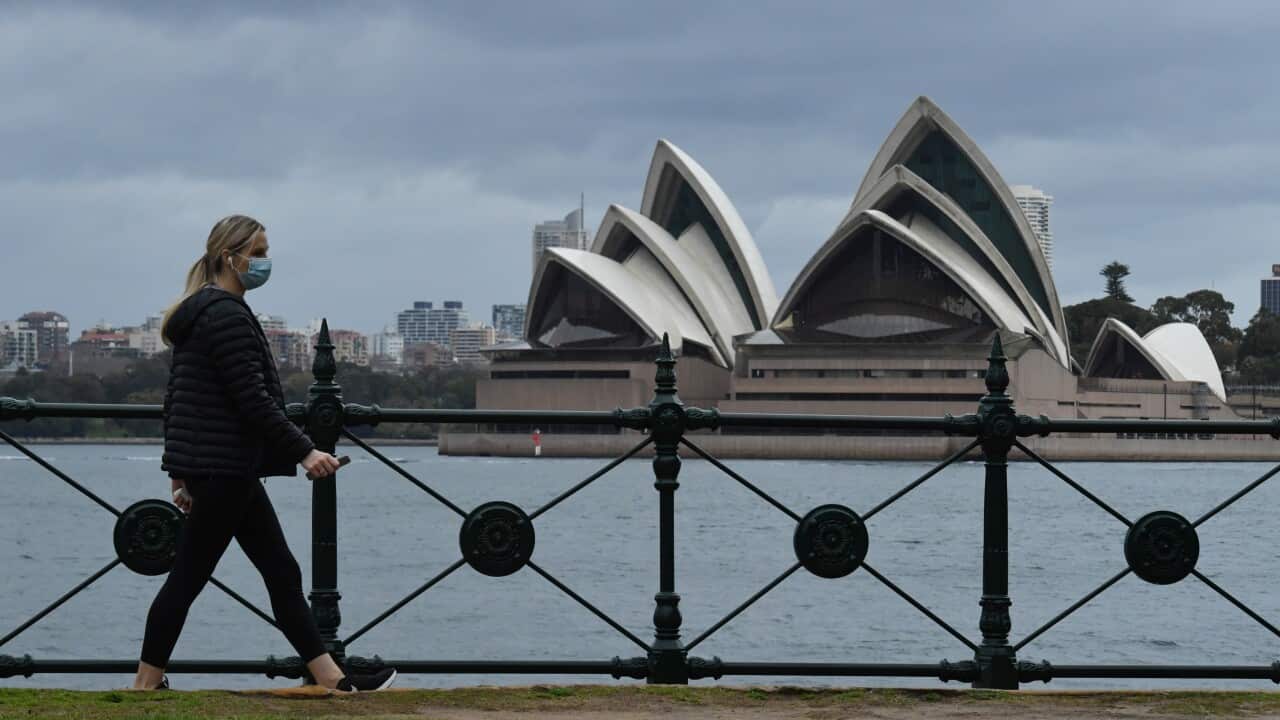 A pedestrian walks past the Sydney Opera House in Sydney.