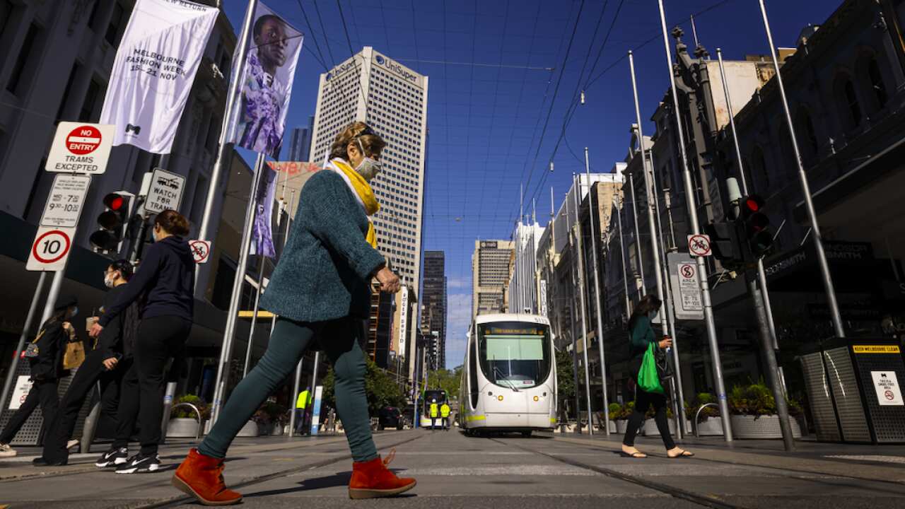 People are seen crossing Bourke Street Mall in Melbourne.