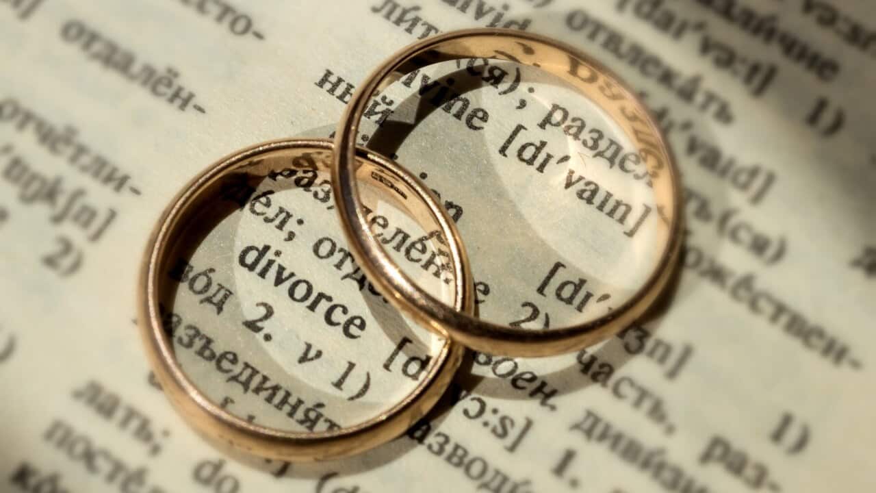 Two separate wedding rings next to the word "divorce". The concept of divorce, parting, infidelity . Selective focus.