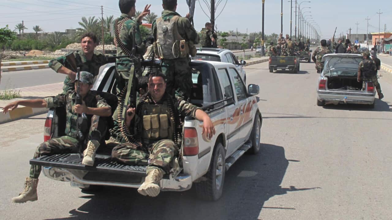 Iraqi police and soldiers parade in the city