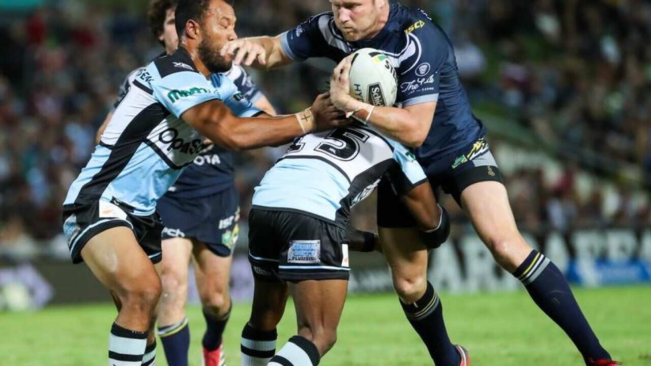 Gavin Cooper of the Cowboys is tackled by Sharks defence.