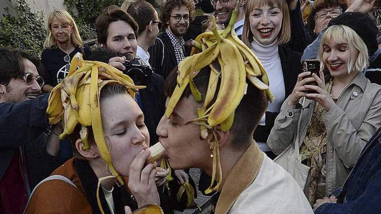 Hundreds of Polish people feed each other bananas in protest of the National Museum's removal of an "indecent" artwork.
