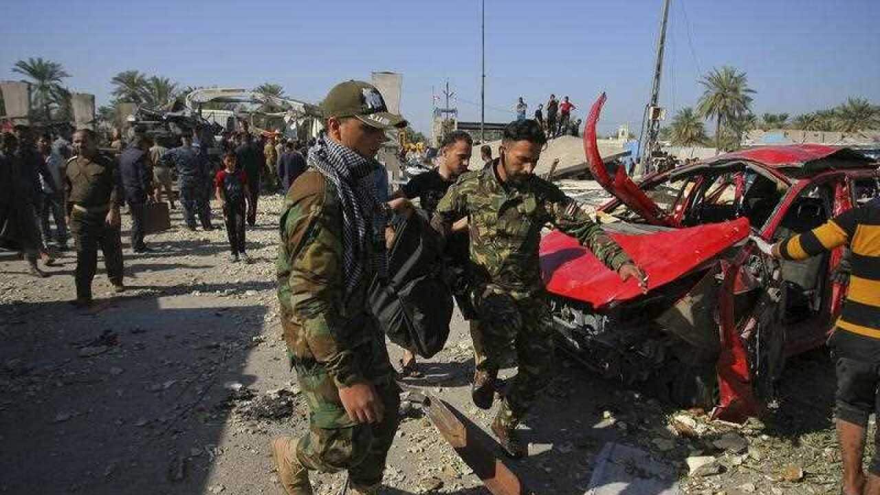 Iraqi security forces evacuate a body of a victim killed from a suicide bomb attack in Hillah, about 60 miles (95 kilometers) south of Baghdad.