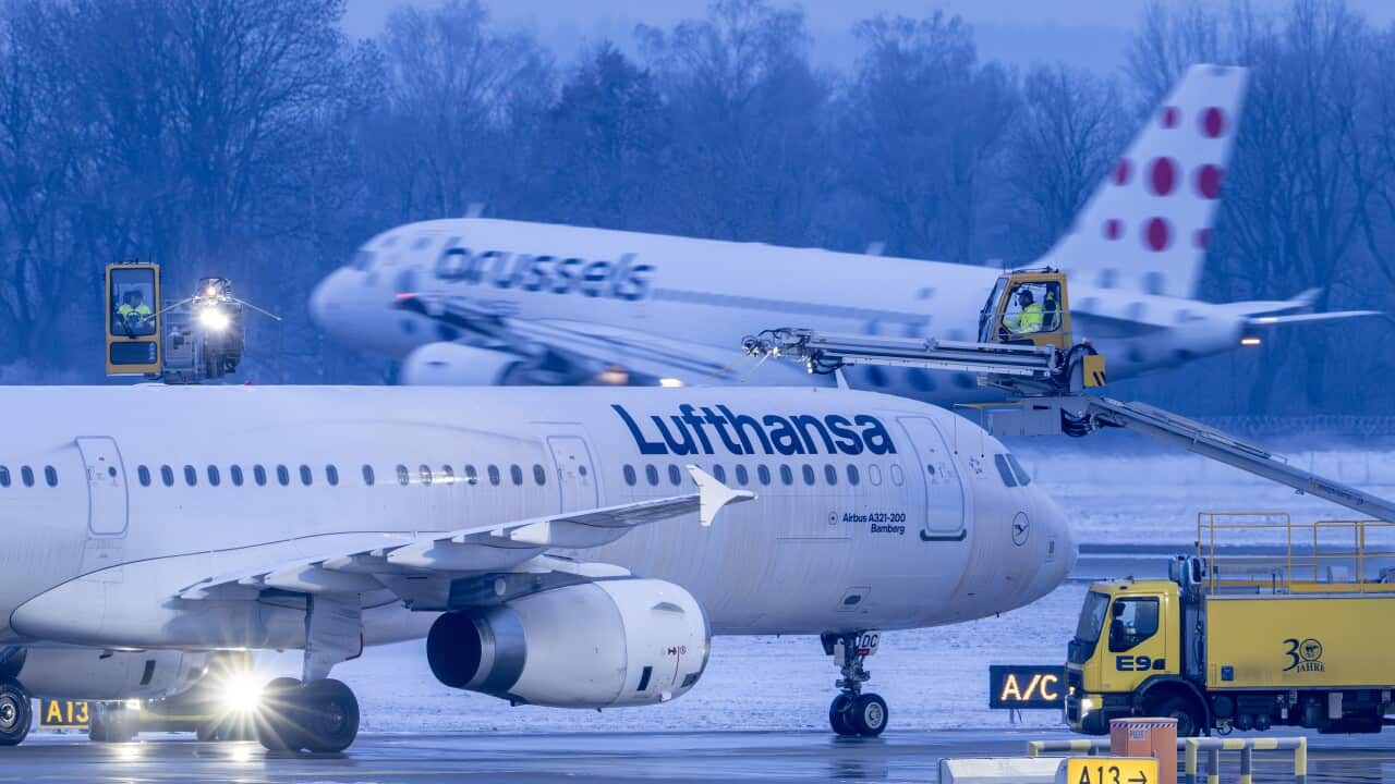 A Lufthansa plane is at the tarmac with another Brussels Airlines plane taking off in the background.