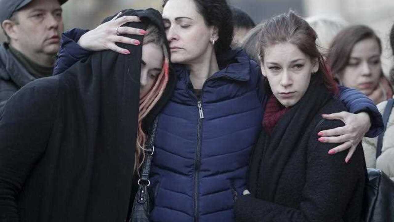 People react at a symbolic memorial at Technologicheskiy Institute subway station in St. Petersburg, Russia, Tuesday, April 4, 2017.