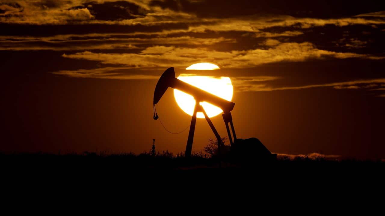 The sun sets behind an idle pump jack near Karnes City, Texas