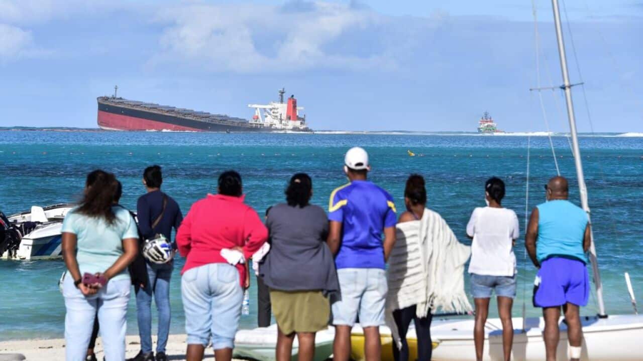 Bystanders look at MV Wakashio bulk carrier that had run aground and from which oil is leaking near Blue Bay Marine Park in south-east Mauritius