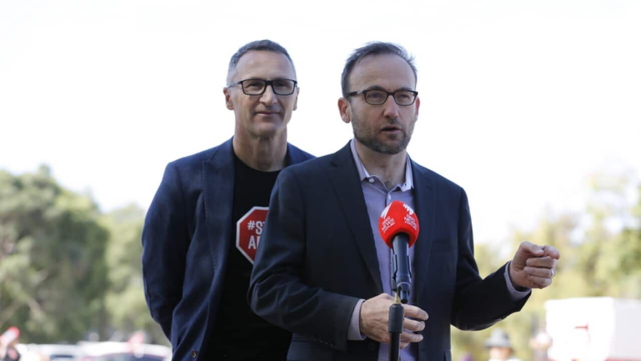 The member for Melbourne Adam Bandt (right) speaks to the media while Greens leader Richard Di Natale looks on during 'Stop Adani Convoy' event in Melbourne.