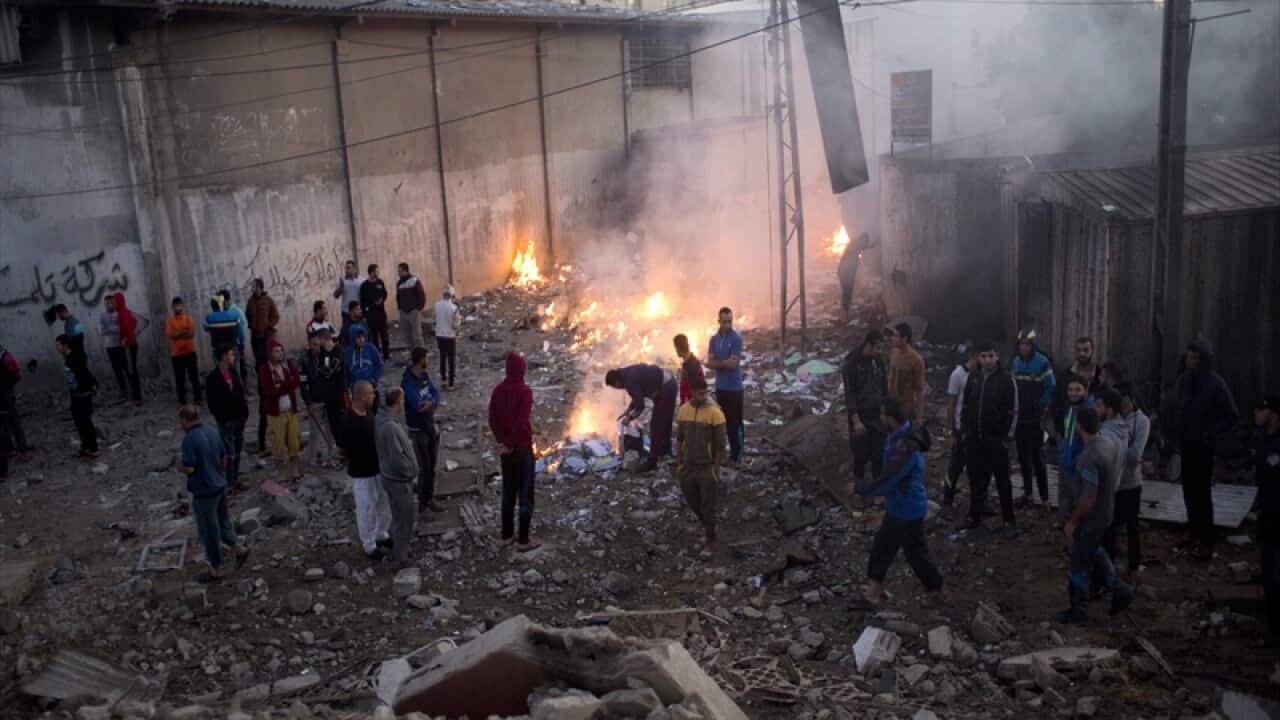 Palestinians in the rubble of destroyed buildings