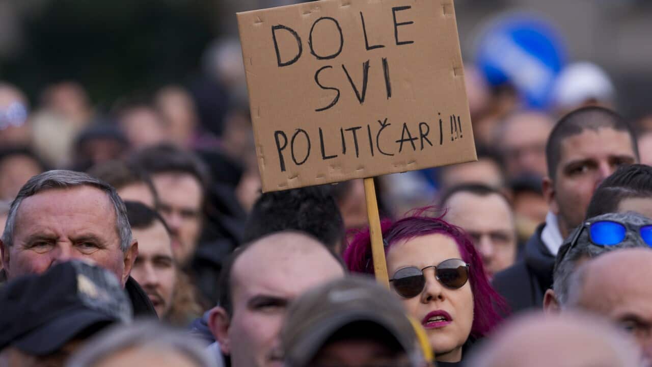 A woman holds a banner that reads in Serbian Down with all politicians!!! during a rally of ProGlas initiative in Nis, Serbia, Sunday, Dec. 10, 2023.