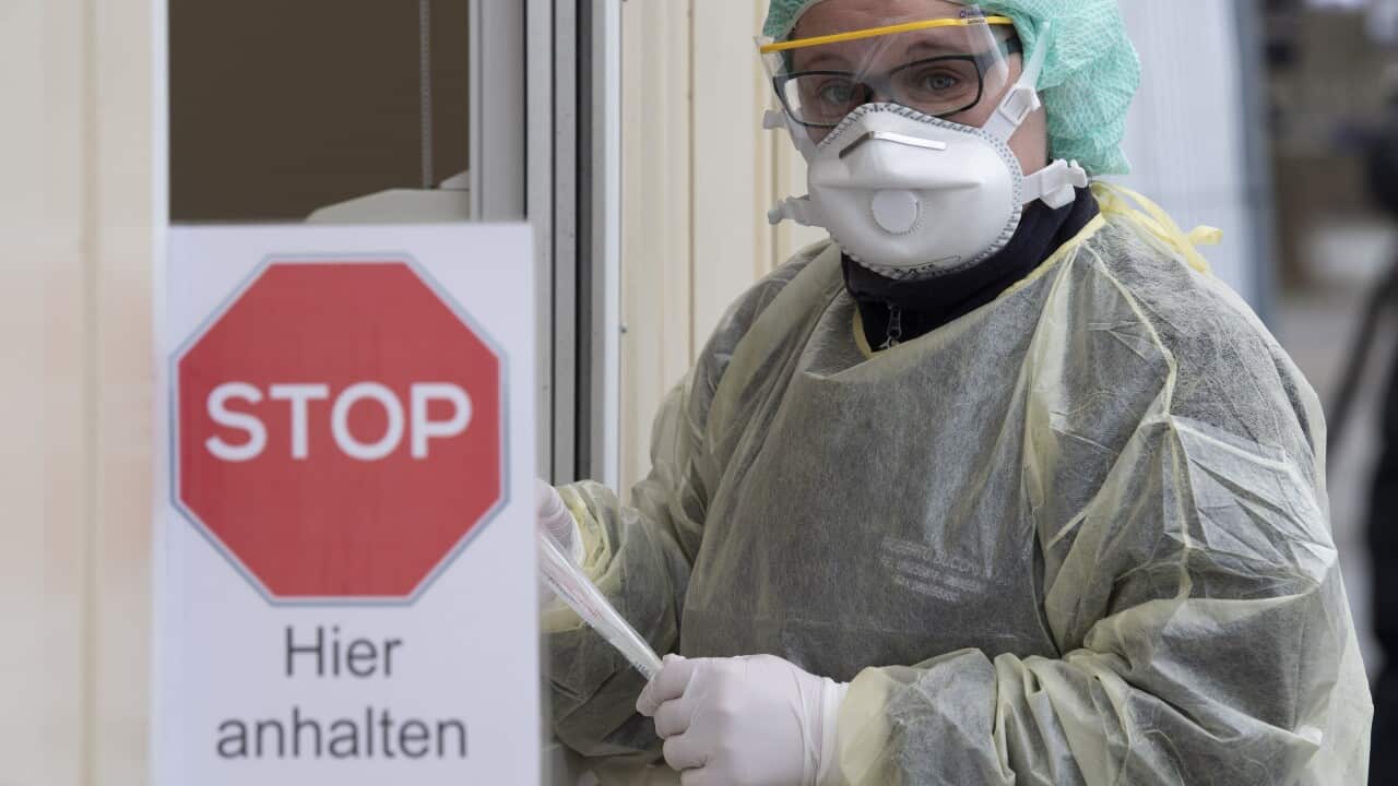 A medical assistant holds a test kit for the novel coronavirus at a new drive-in testing facility in Nuertingen, southern Germany.