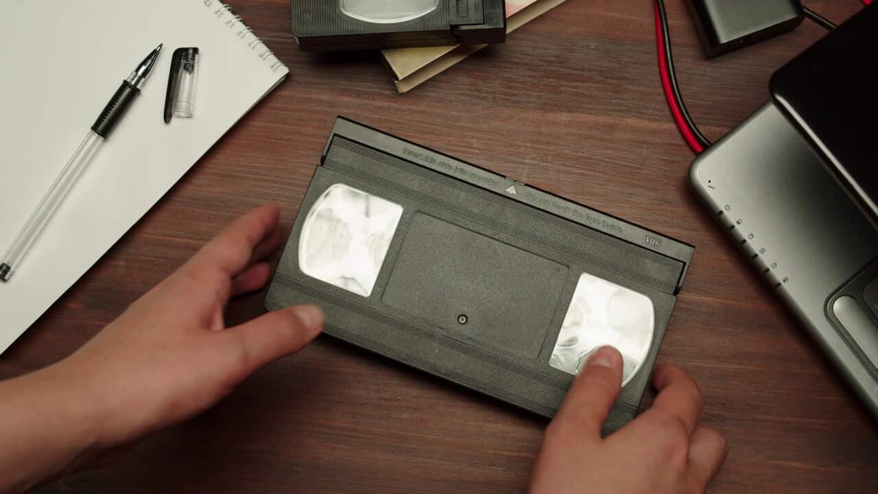 hands-holding-old-video-cassette-close-up-using-obsolete-videotape-old-fashioned-recor-SBI-350483904.jpg