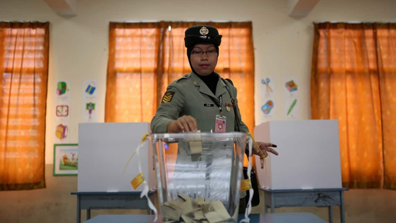 A Malaysian armed forces officer casts her vote during an early vote for the 13th general elections at a military base in Kuala Lumpur. (AFP)