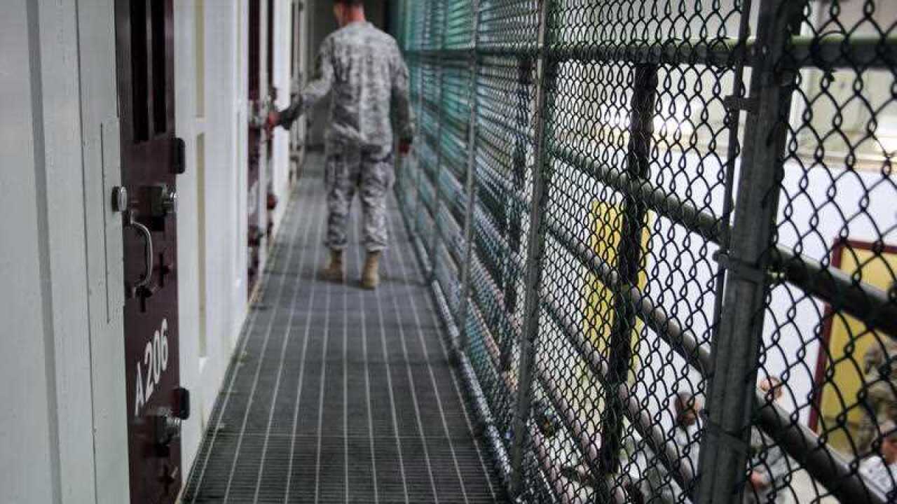 An Army captain walks outside unoccupied detainee cells inside Camp 6 at the U.S. detention center at Guantanamo Bay