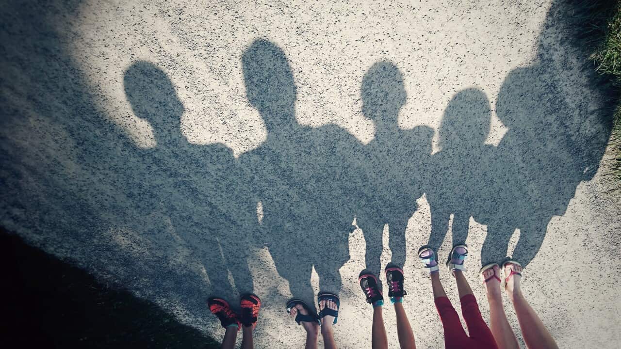 Shadows on a gravel path of a family of five