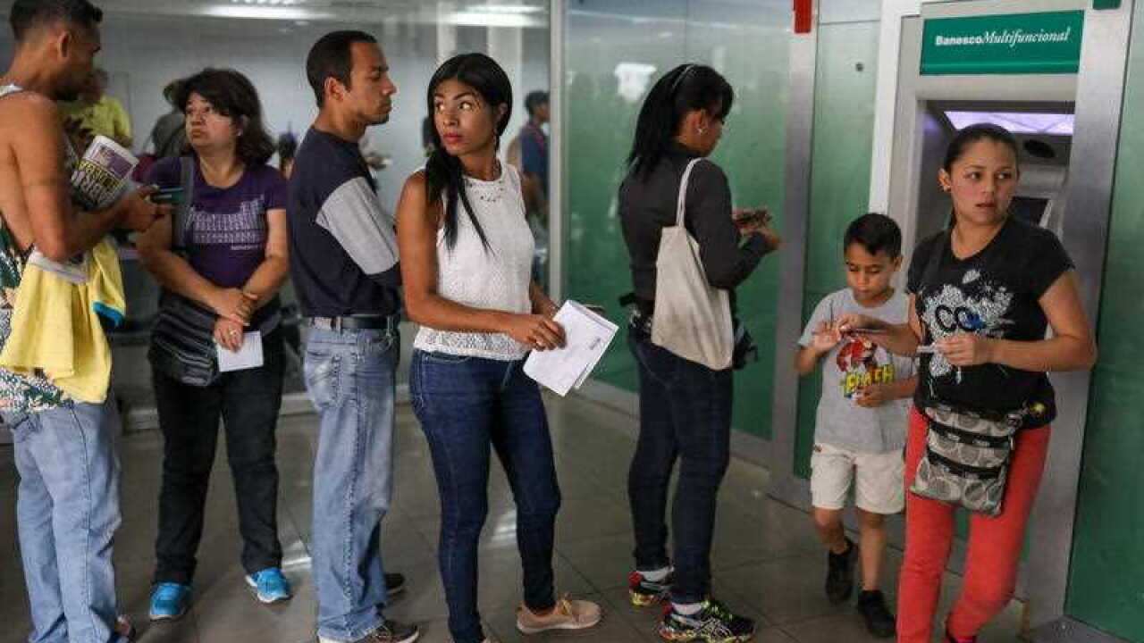 Clients queue at a banking institution to withdraw money from the entity, in Caracas, Venezuela, 21 August 2018.
