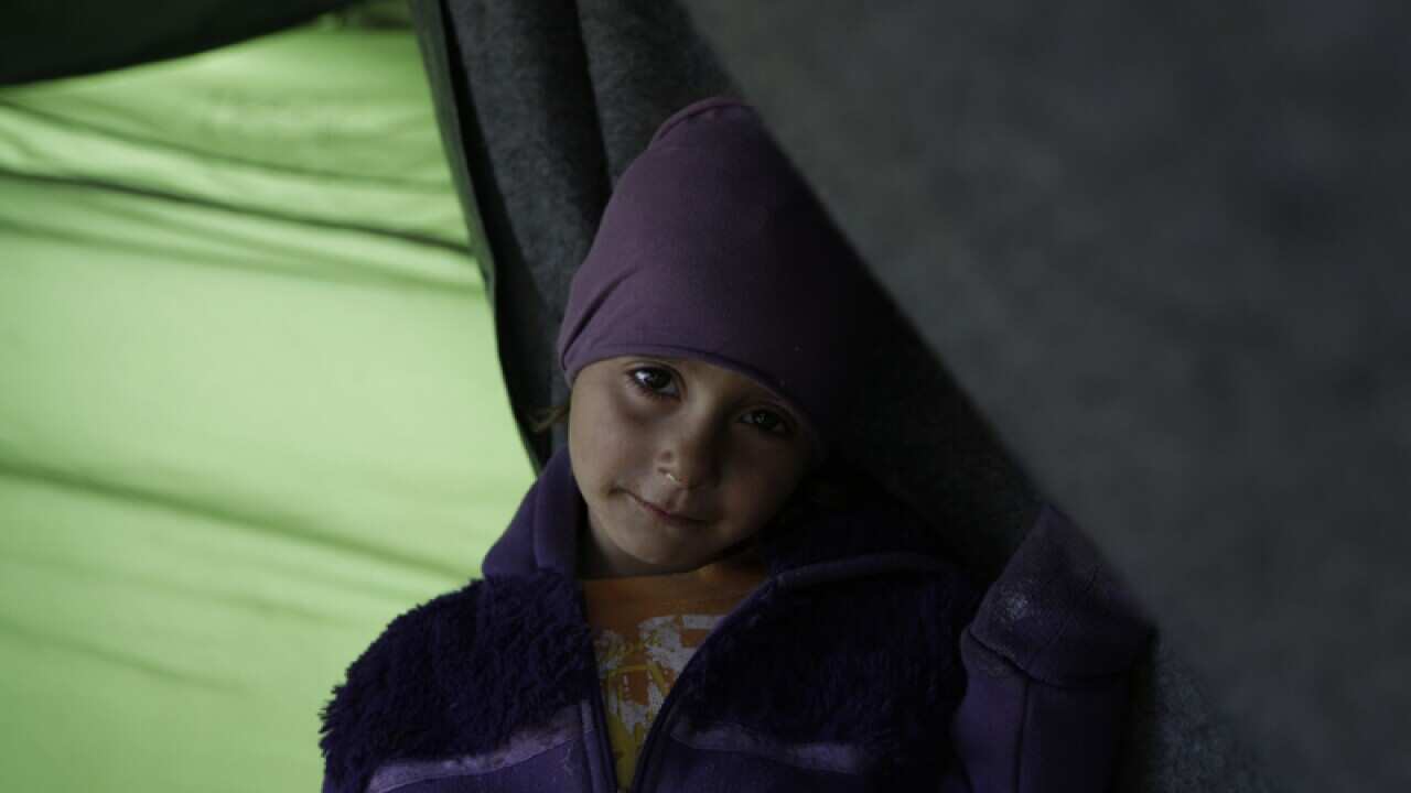 A migrant girl at the northern Greek border point of Idomeni, Greece