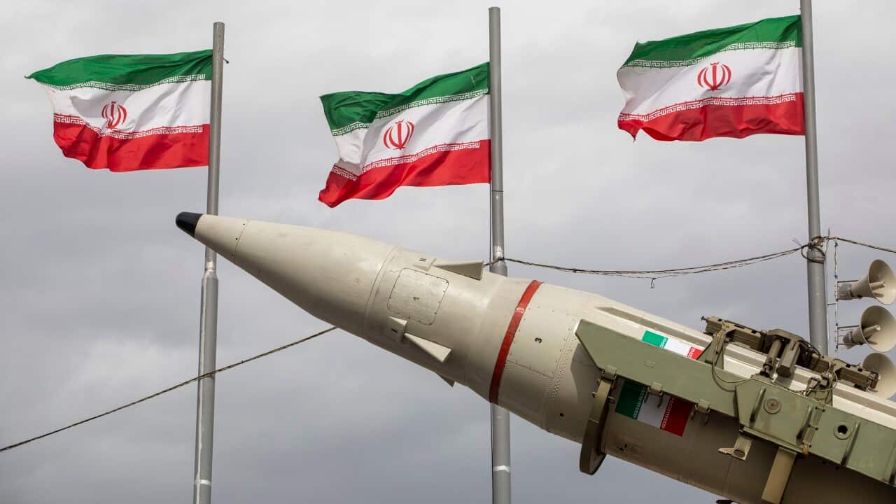 Missiles produced by Iran's armed forces are displayed near a row of Iranian flags (Getty)