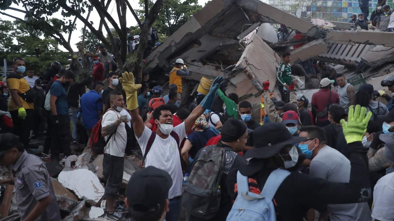 Rescue workers operate at the site of a collapsed building following an earthquake in Cali, Colombia (AAP)