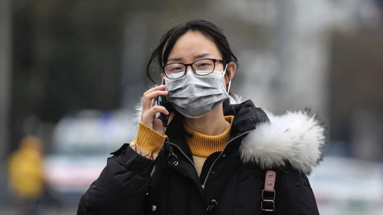 A woman wears a mask outside the closed Huanan Seafood Wholesale Market, January 17, 2020 in Wuhan, Hubei province, China