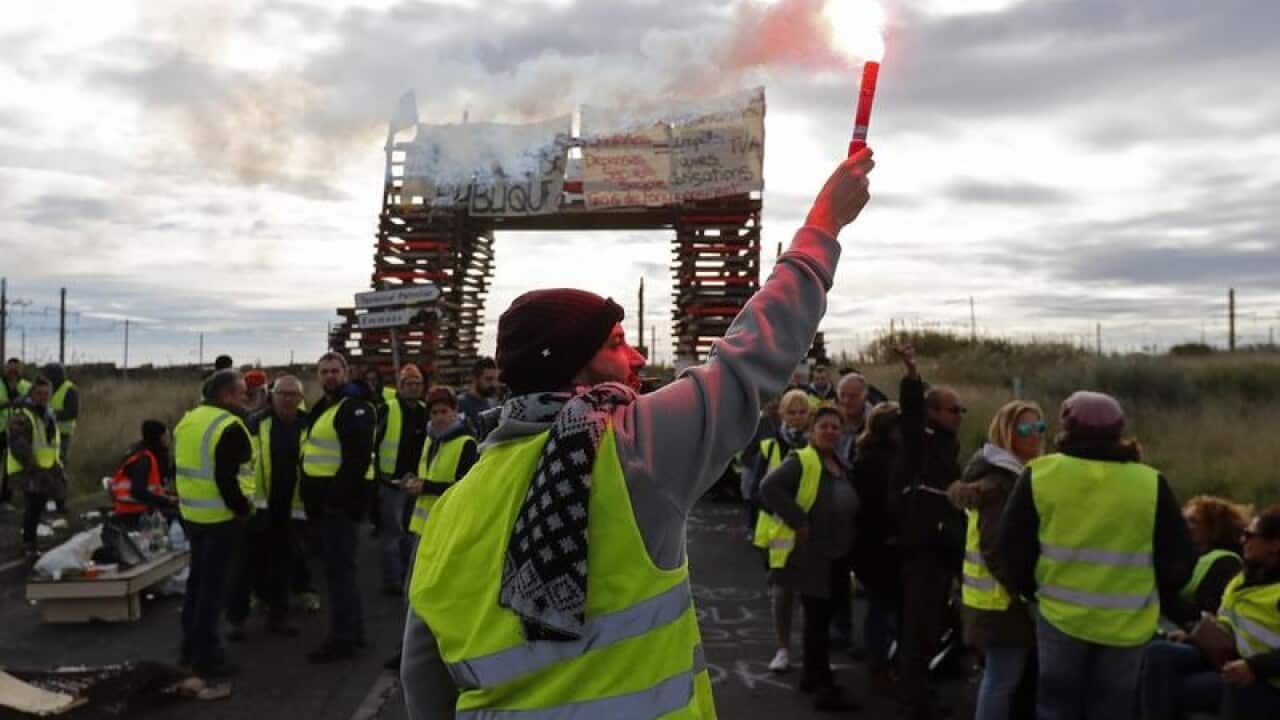 People wearing yellow vests block access to an oil refinery in France