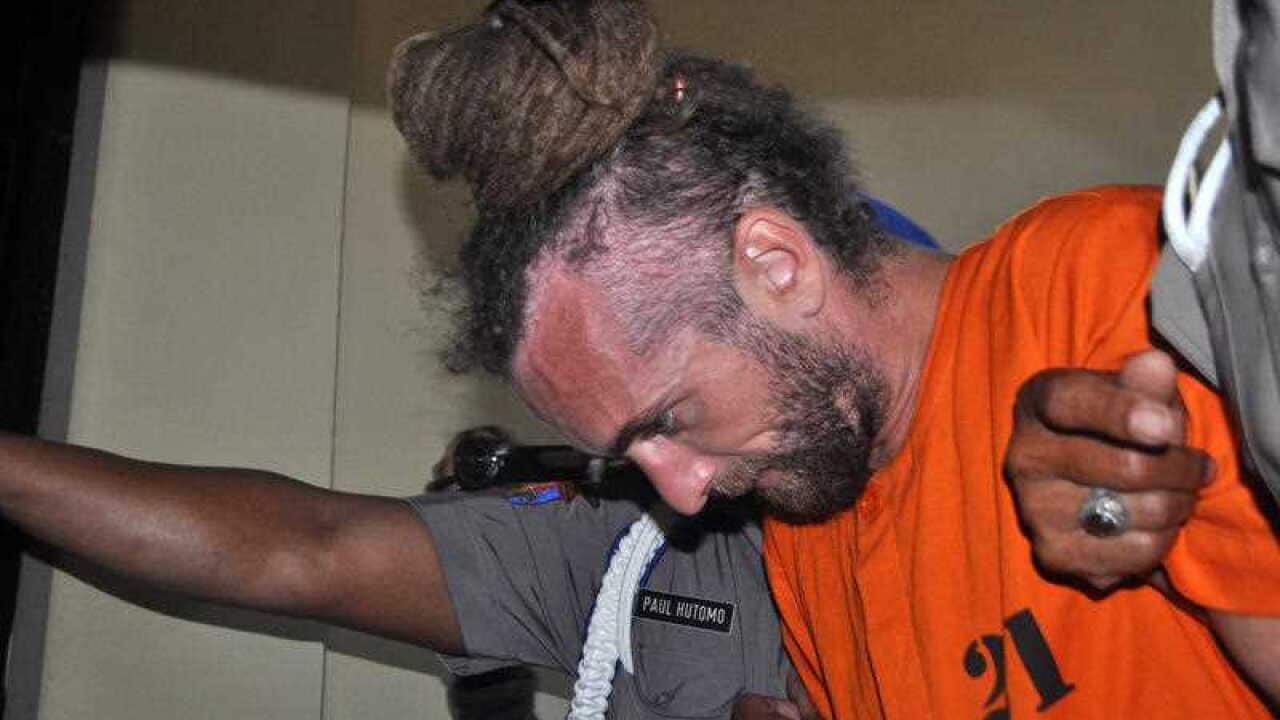 British man David Taylor being taken from his holding cell at Denpasar police station, in Bali, Indonesia, Monday, Aug. 22, 2016.