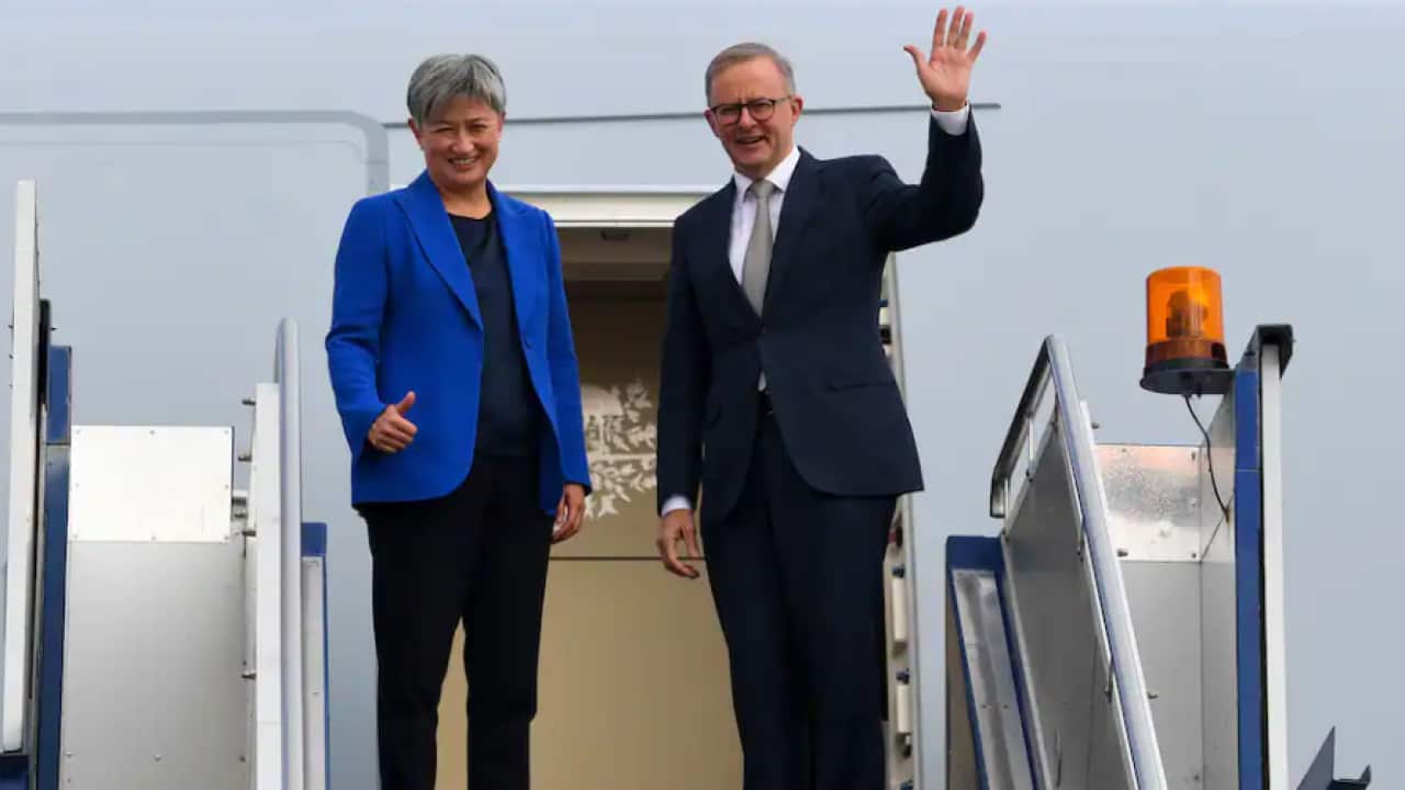 Prime Minister Anthony Albanese and Australian Foreign Minister Penny Wong wave as they board the plane to Japan to attend the QUAD leaders meeting in Tokyo, Canberra.