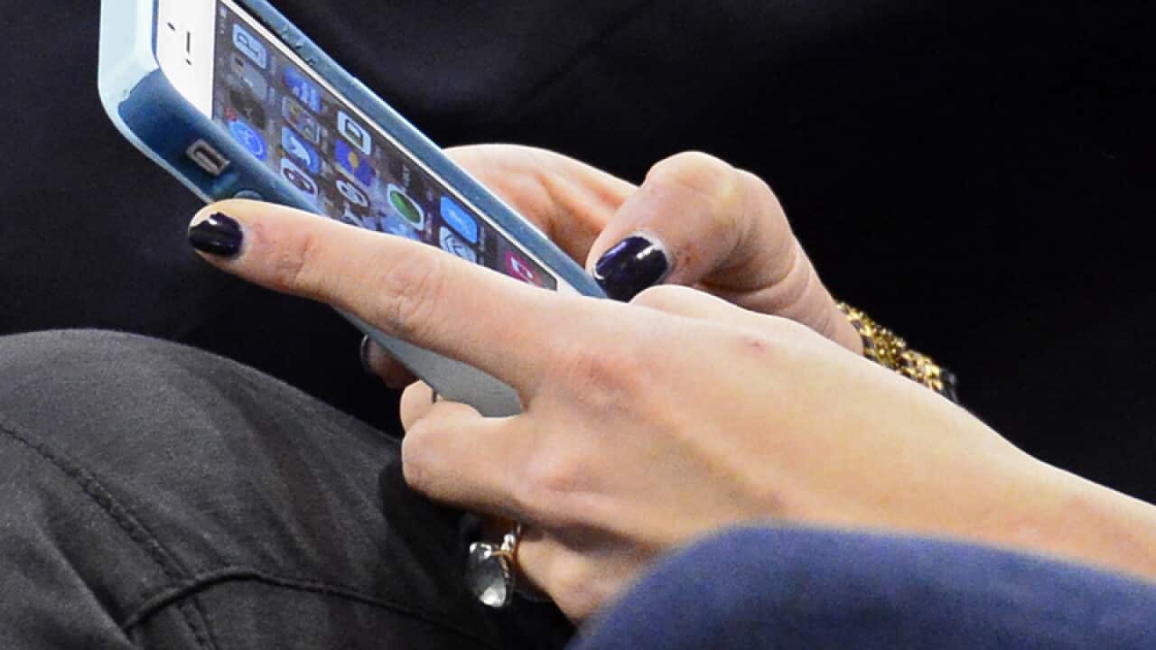 A person uses their iPhone