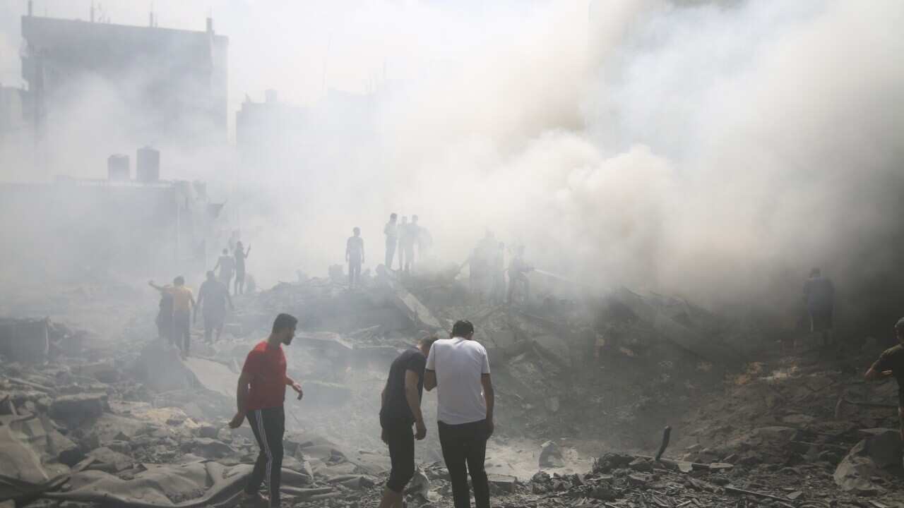 People standing in rubble after a missile strike