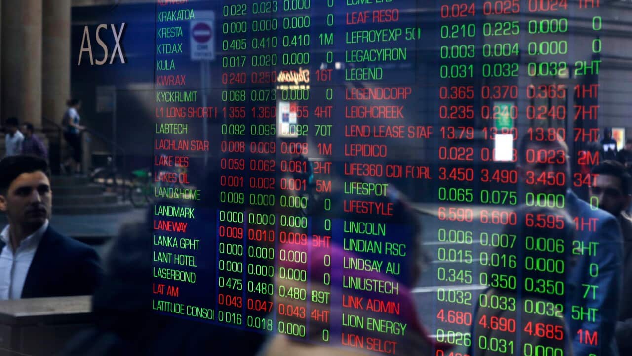 People are reflected in window as they pass Australian Stock Exchange in Sydney