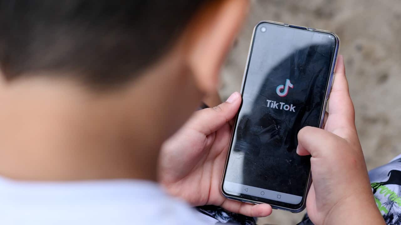 Young boy looking at TikTok on a mobile phone