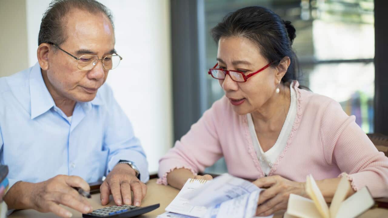 Senior couple working with bills at table