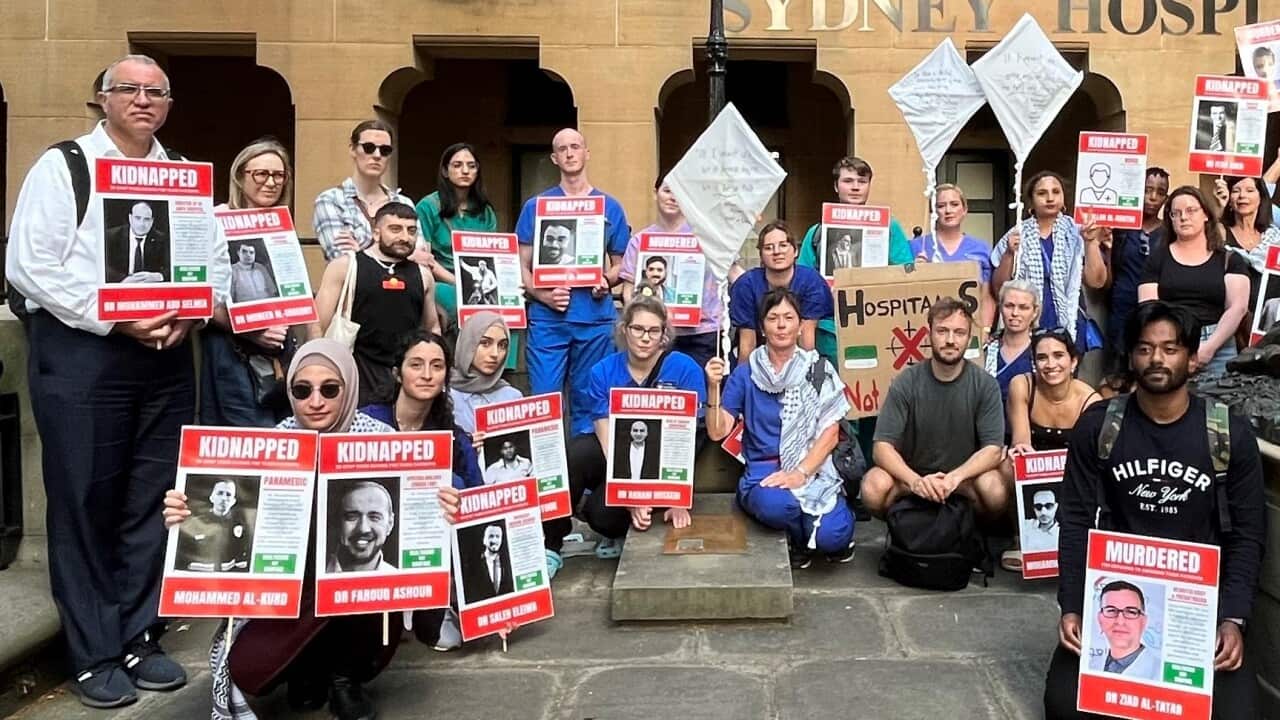 A group of people holding the posters in front of the Sydney hospital