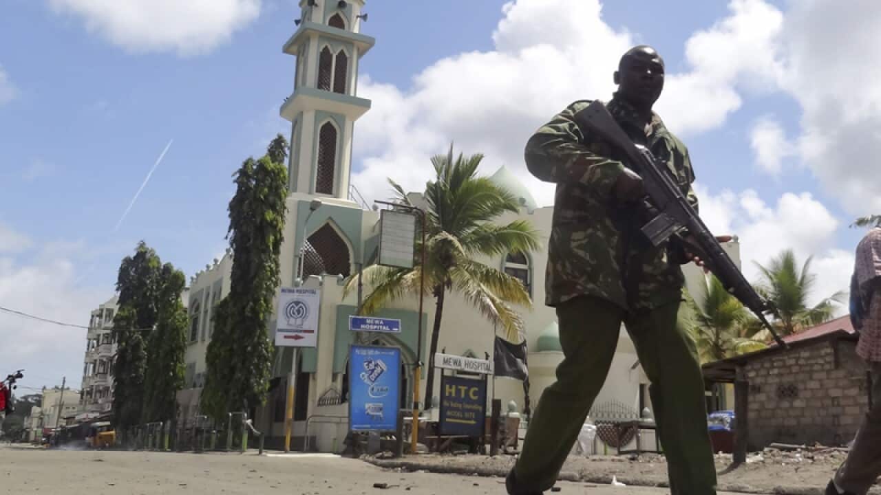 An armed Kenyan policeman patrols past the Masjid Musa Mosque,Kenya