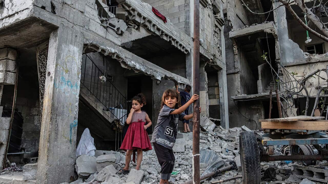 Palestinian children play in front of their destroyed homes in Beit Hanoun following Israeli airstrikes in Gaza.