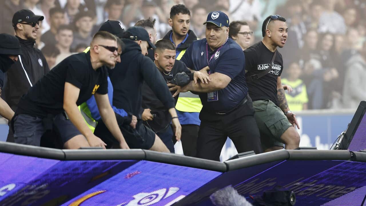 Fans storm the pitch at the Melbourne derby.
