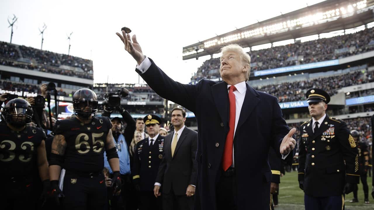 President Donald Trump tosses the coin ahead of an NCAA college football between Army and Navy, Saturday, Dec. 8, 2018, in Philadelphia.