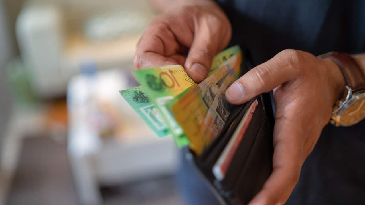 Hands taking money out of wallet.
