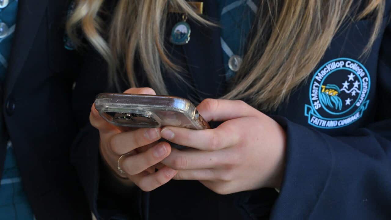 Photo of teenager's hands, using a mobile phone.