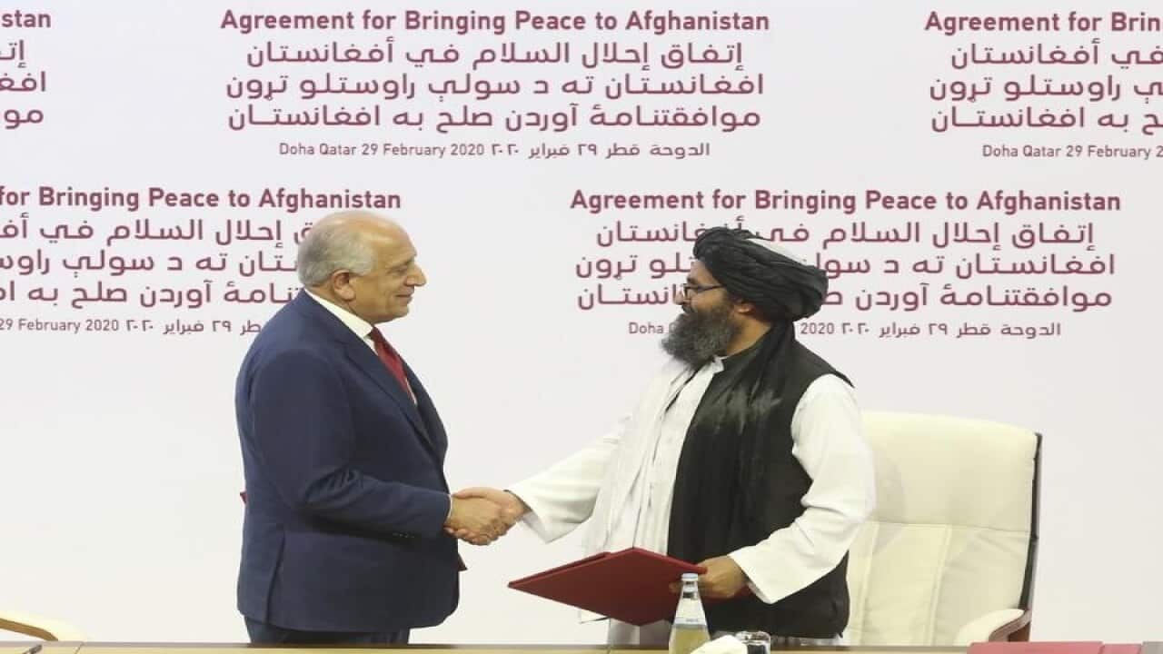US peace envoy Zalmay Khalilzad (L) and Mullah Abdul Ghani Baradar