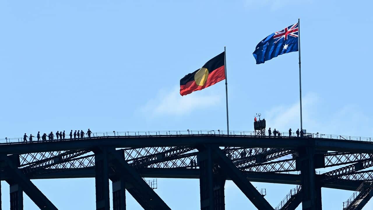 The Australian Aboriginal and Australian national flags are seen on top of the Sydney Harbour Bridge during Australia Day 2022 celebrations, in Sydney, Wednesday, January 26, 2022 (AAP Image/Bianca De Marchi) NO ARCHIVING