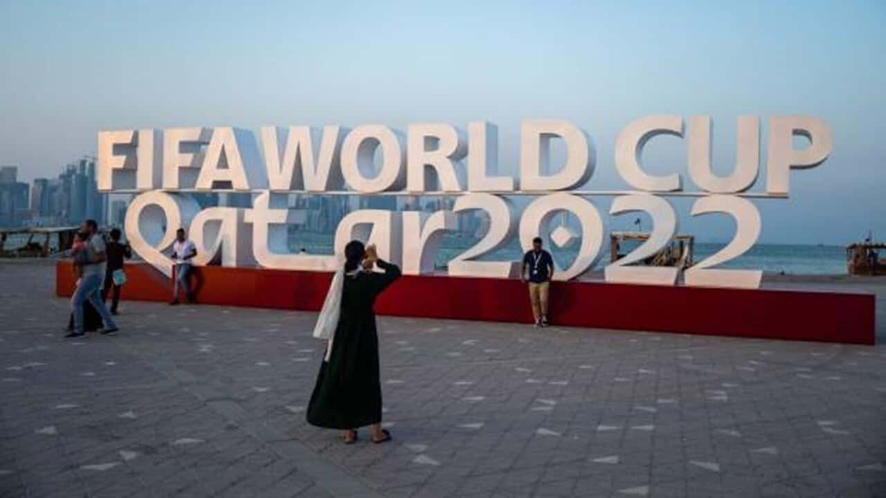 Visitors take photos with a FIFA World Cup sign in Doha.jpg