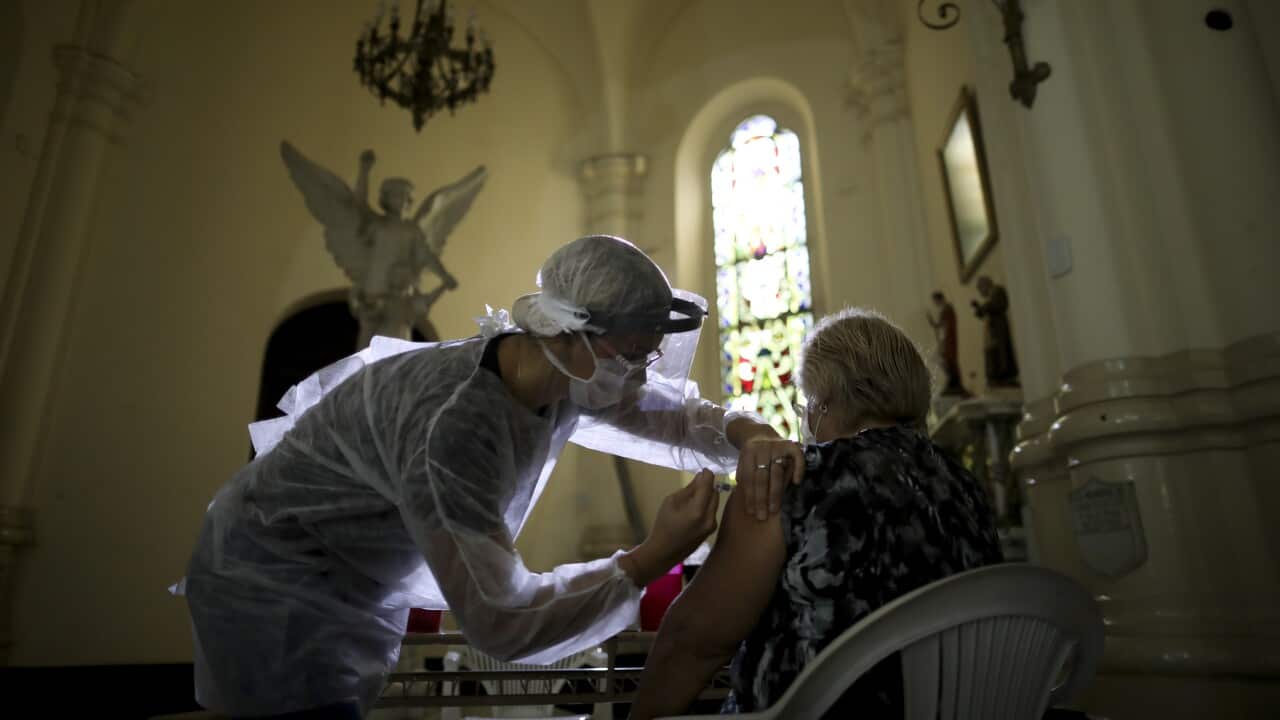 A medical worker administers a flu vaccine inside a church as part of a government vaccination campaign, in Buenos Aires, Argentina, Saturday, April 11, 2020.