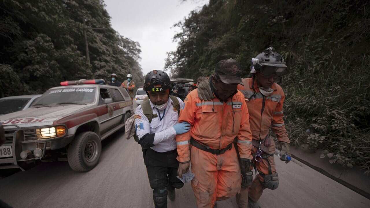 Guatemalan firefighters leave the evacuation area near Volcan de Fuego.