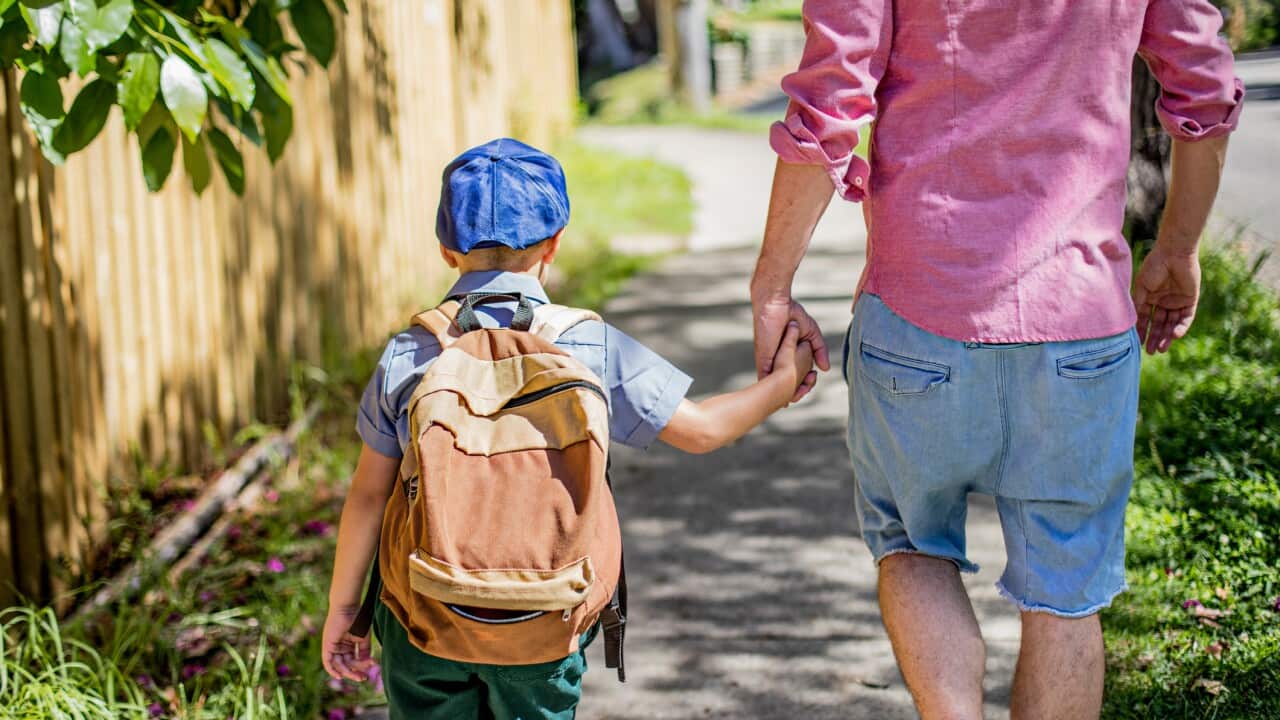 Father and son walking to school
