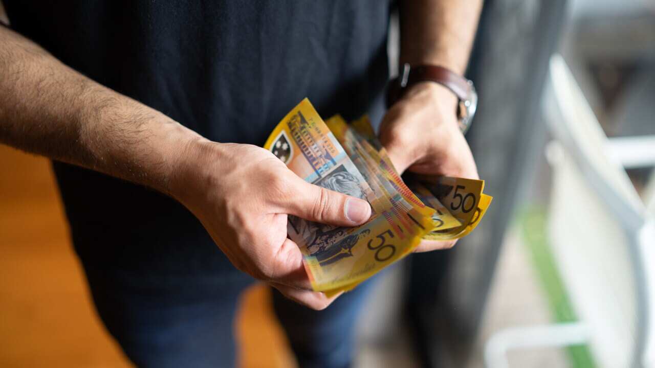 young male counting australian dollars
